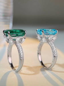 Makroaufnahme von Silberringen mit Smaragd und Aquamarin im Treppenschliff und Diamanten