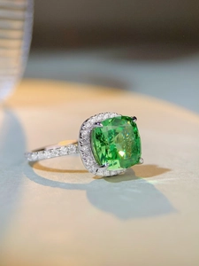 Macro d'une bague en argent S925 avec pierre verte émeraude et sertissage halo pavé