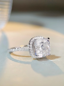 Gros plan d'une bague en argent taille coussin avec anneau serti de diamants