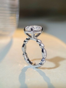 Détail macro de la bague diamant ovale avec serti à quatre griffes et anneau perlé