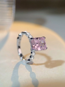 Gros plan détaillé d'une bague en argent avec pierre rose carrée et pavage de zircons