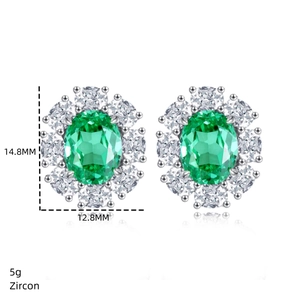 Detail view of oval emerald green zircon earrings with white stones in silver setting
