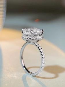 Vue latérale macro d'une bague en argent taille radiant avec halo et sertissage pavé étincelant