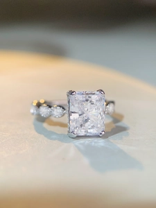 Vue macro latérale d'une bague avec pierre taille radiant et pierres d'accent en argent