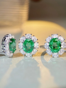 Macro shot of S925 silver earring and ring set with oval green zircon and micro pavé crystals