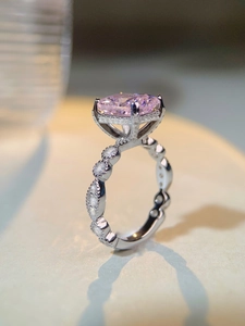 Détail de la bague en argent avec pierre rose taille coussin et anneau pavé ondulé