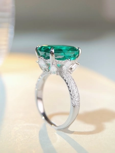 Dettaglio macro della pietra verde smeraldo con micro diamanti sulla fascia in argento