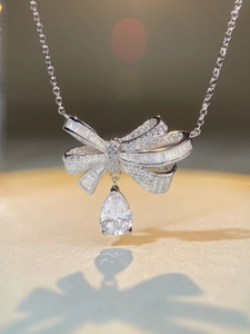 Macro shot of silver S925 bow necklace with sparkling waterdrop zircon pendant
