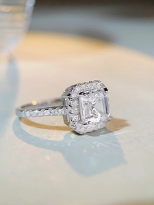 Vue latérale macro d'une bague taille émeraude avec halo de diamants sur argent S925