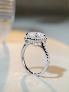 Vue latérale détaillée de la bague taille émeraude avec halo et support évidé