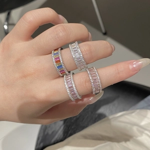 Detail of four S925 silver rainbow rings with baguette-cut zircons worn on model's hand