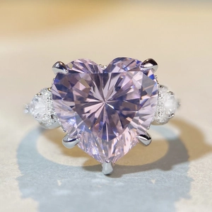 Gros plan d'une bague en argent avec zircon rose en forme de cœur et serti à griffes