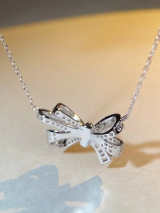 Dettaglio macro della collana con ciondolo a fiocco in argento e zirconi pavé