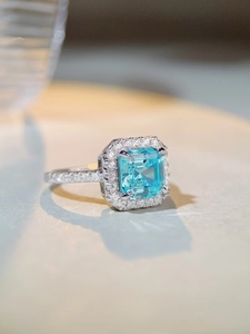 Macro detail of high-clarity aquamarine square cut ring with pavé diamond halo setting