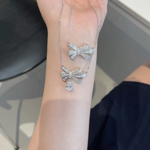 Detail of S925 silver bow necklaces with pave zircons and pear-cut drop pendant