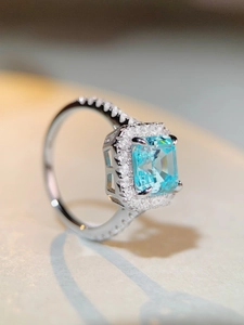 Macro shot of emerald-cut aquamarine zircon ring with micro-pave S925 silver setting