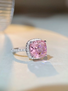 Detailed view of cushion cut pink gemstone ring with halo diamonds and pavé band
