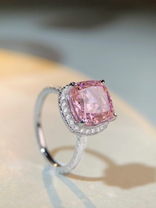 Macro shot of 5 carat pink cushion cut gemstone ring with halo diamond setting