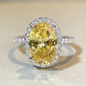 Macro view of luxurious oval yellow zircon ring with halo pave and silver band