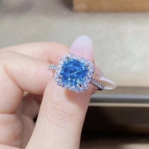Macro shot of S925 silver ring featuring radiant cut blue gemstone with halo diamonds
