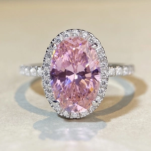 Macro d'une bague ovale en pierre rose avec halo de diamants et anneau en argent