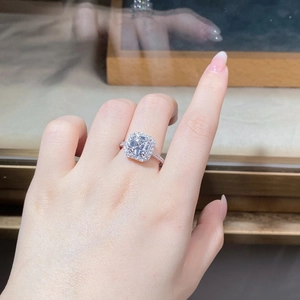 Détail d'une bague en argent avec pierre taille émeraude et entourage halo pavé