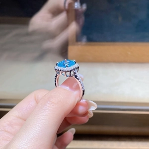Detailed side view of halo square sea blue gemstone ring with pave diamond band