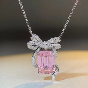 Vue macro d'un collier en argent S925 avec gemme rose rectangulaire et pendentif nœud