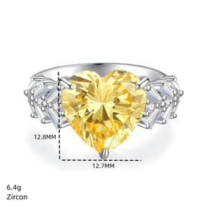 Macro view of heart-shaped yellow zircon ring with silver-white metal band and side stones