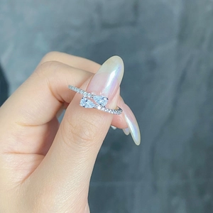 Close-up of S925 silver open ring with dual pear-shaped blue stones and pave zircons