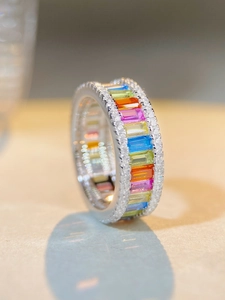 Detailed macro view of rainbow baguette-cut gemstone ring with micro-pave white zircon edges