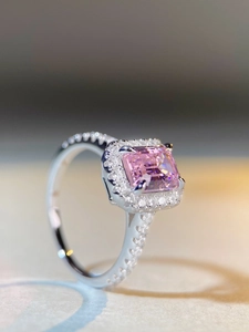 Macro shot of square pink gemstone ring with halo diamonds and pavé band details