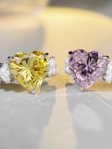 Macro detail of heart-shaped yellow and pink gemstones with baguette-cut side diamonds
