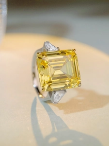 Macro shot of emerald-cut yellow carbon diamond ring with trapezoid side stones