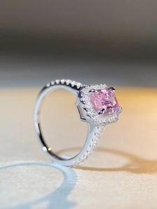 Macro shot of square pink gemstone ring with halo diamonds and pavé silver band