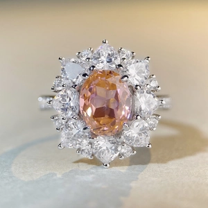 Macro d'une bague en argent avec pierre ovale rose-orange et pierres en forme de cœur