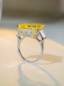 Detail view of large rectangular yellow stone ring with heart cutout on band