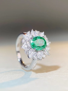 Gros plan d'une bague ovale en pierre précieuse verte Paraïba avec double halo de diamants