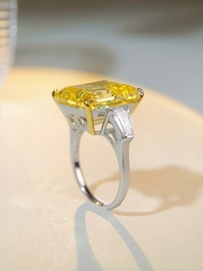 Macro view of rectangular radiant cut yellow gemstone ring with baguette side stones