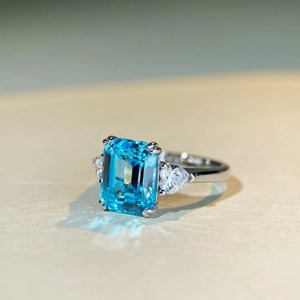 Macro detail of rectangle light blue gemstone ring with triangular side diamonds
