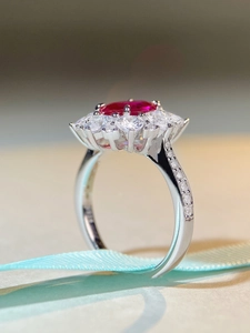 Macro shot of oval ruby halo ring with sterling silver micro-pave diamond settings