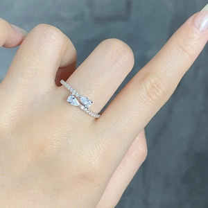 Detail of S925 silver ring featuring two pear-cut stones and pavé set diamonds on a model hand