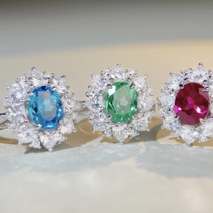 Vue détaillée de trois bagues en pierres ovales de couleur bleue, verte et rouge rubis