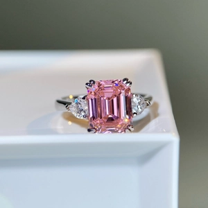 Macro detail of S925 silver ring featuring emerald cut pink gemstone and pear cut side stones
