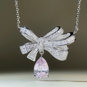 Bowknot silver necklace with pavé cubic zirconia and a pear-cut pink drop pendant
