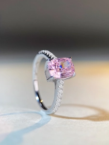 Macro view of radiant cut pink gemstone ring with micro-pave silver band detail