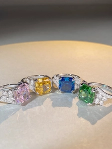 Close-up of vibrant rectangular sapphire rings in pink, yellow, blue, and green finishes