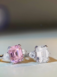 Vue macro de pierres de taille émeraude et poire sur des bagues en argent rose et blanc