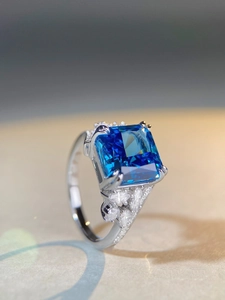 Macro view of square blue gemstone ring with detailed side-set diamond marquise accents