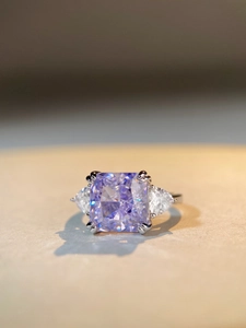 Macro view of a 5-carat lavender radiant-cut zircon ring with pear-shaped side stones